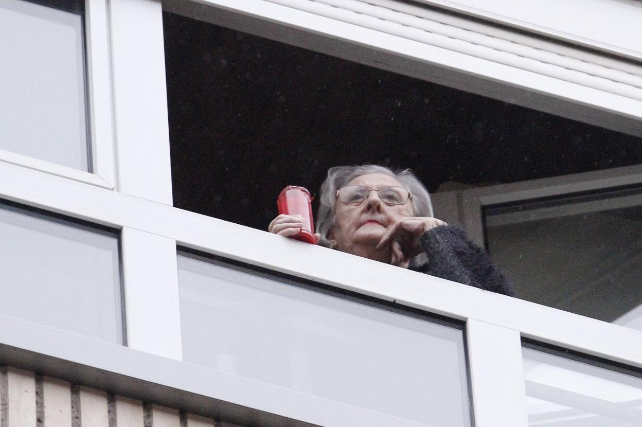 En la calle Leopoldo Alas de Gijón los vecinos se sumaron ayer por la tarde a la iniciativa de sacar velas y guardar un minuto de silencio por todas las víctimas que se ha cobrado la pandemia. 