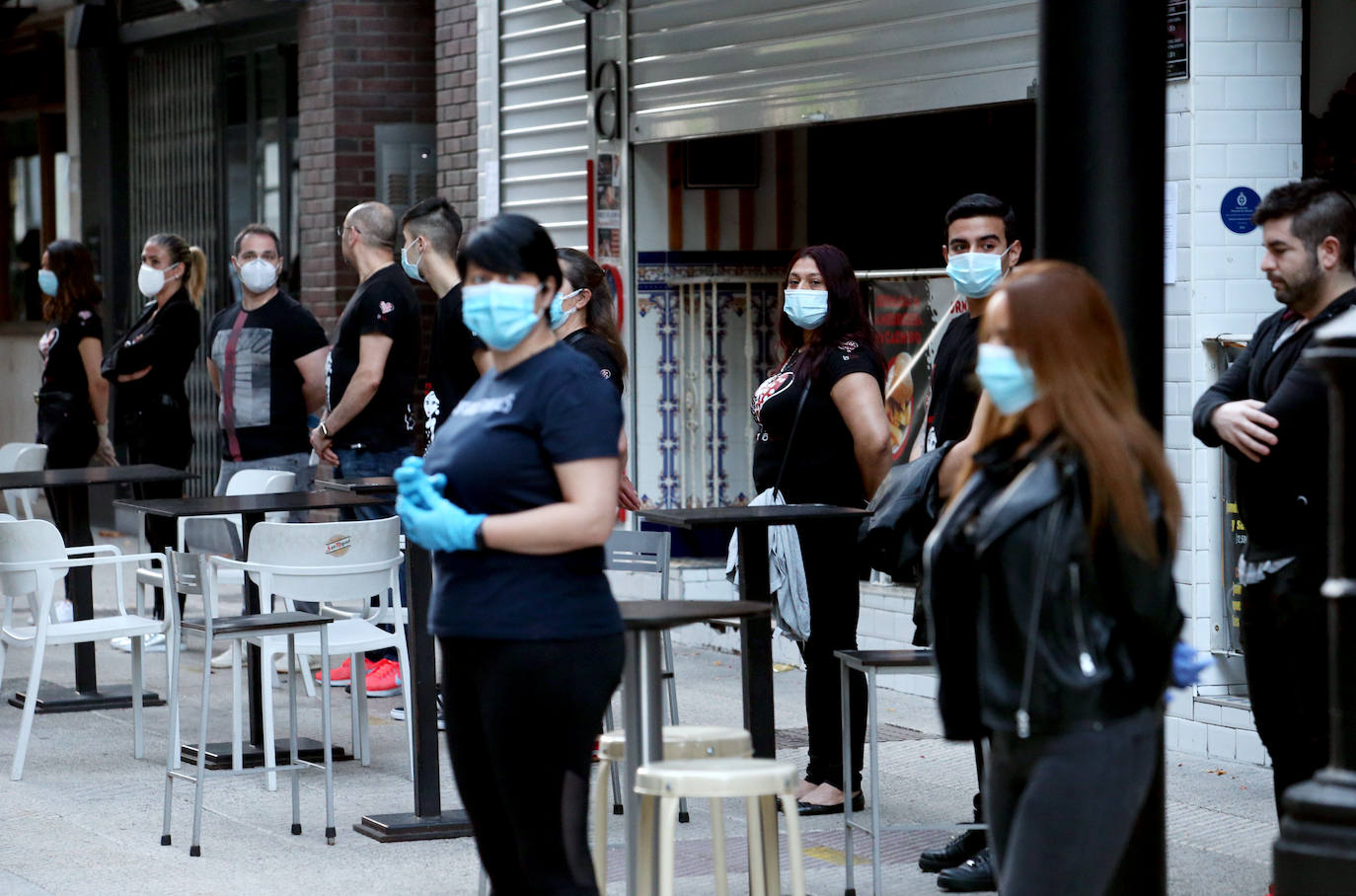 Los hosteleros salieron a la puerta de sus negocios vestidos de negro para rechazar las limitaciones a su trabajo impuestas desde el Gobierno central.