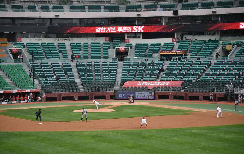 La pandemia de Covid-19 no ha frenado el inicio de la liga de béisbol de Corea del Sur, que ha comenzado este martes. Eso sí, por el momento los partidos se disputarán a puerta cerrada, aunque algunos estadios han colocado pancartas con personas dibujadas para que sus gradas parezcan más llenas. 
