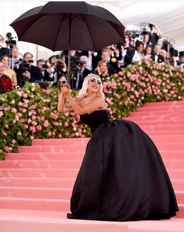 Con ayuda de unos 'performers' que llevaban paraguas se quitó el traje para mostrar un vestido palabra de honor de corte princesa en color negro.