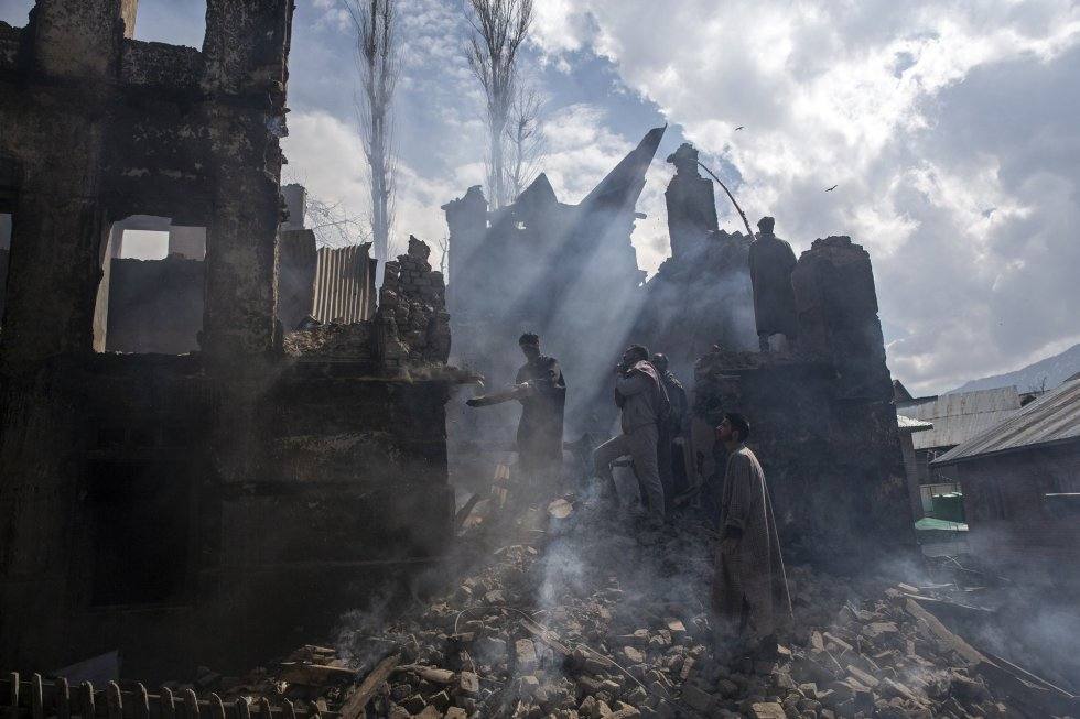 Un grupo de hombres quitan las piedras de una casa destruida durante unos enfrentamientos con la policía india en la aldea de Tral, en Cachemira, 4 de marzo de 2019. Autor: DAR YASIN (AP)
