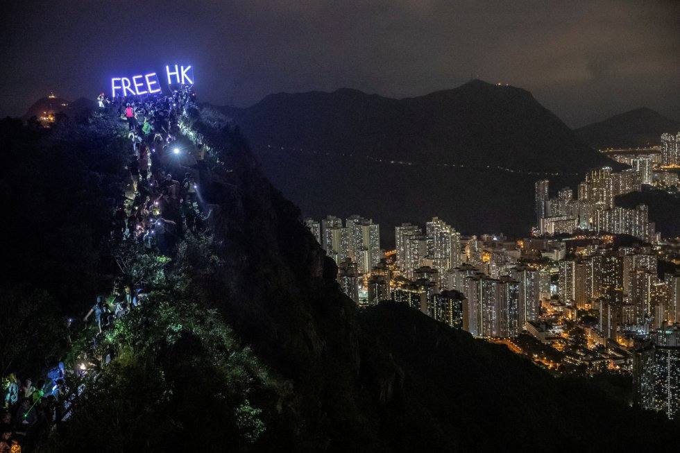 Cientos de manifestantes antigubernamentales tras subir a la cima de Lion Rock, mientras sostienen un cartel luminoso donde se puede leer 'Hong Kong libre', el 13 de septiembre de 2019. Autor: ATHIT PERAWONGMETHA (REUTERS)
