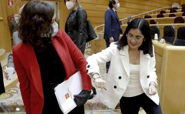 La ministra Carolina Darias saluda con el codo a la presidenta de Madrid, Isabel Díaz Ayuso, en el Senado.