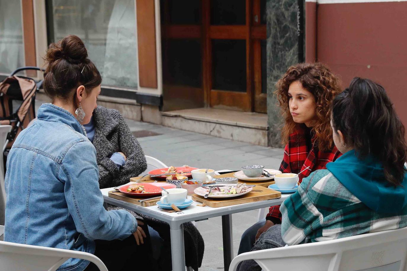 Tras ocho semanas con las verjas bajadas y las sillas y mesas apiladas, los establecimientos hosteleros de Gijón han vuelto a colocar sus terrazas. Eso sí, bajo estrictas medidas de higiene y aforo para prevenir el contagio de coronavirus. 