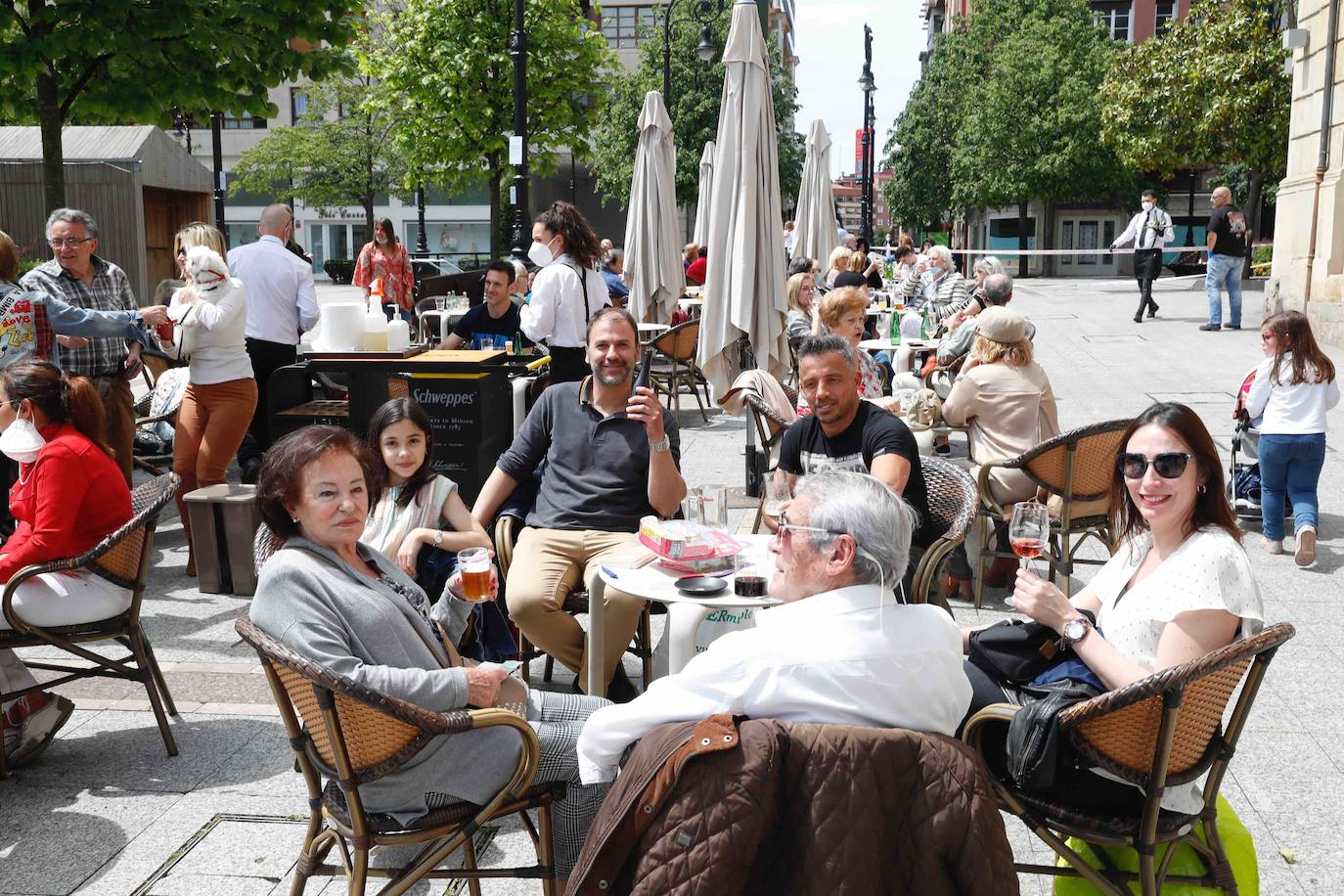 Tras ocho semanas con las verjas bajadas y las sillas y mesas apiladas, los establecimientos hosteleros de Gijón han vuelto a colocar sus terrazas. Eso sí, bajo estrictas medidas de higiene y aforo para prevenir el contagio de coronavirus. 