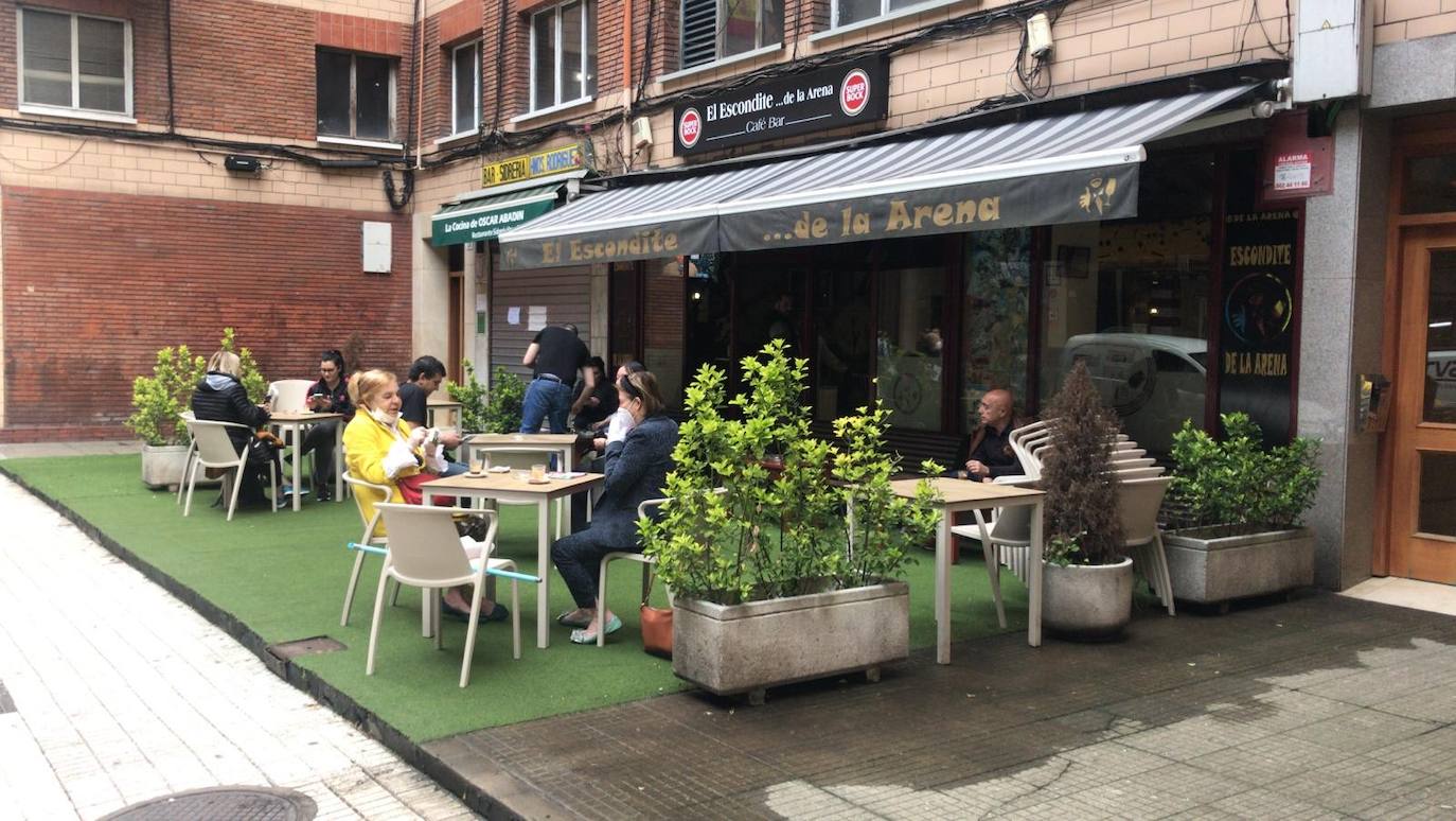 Tras ocho semanas con las verjas bajadas y las sillas y mesas apiladas, los establecimientos hosteleros de Gijón han vuelto a colocar sus terrazas. Eso sí, bajo estrictas medidas de higiene y aforo para prevenir el contagio de coronavirus. 