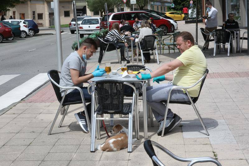 Por primera vez desde que se declaró el estado de alarma por la pandemia de coronavirus los asturianos han podido acudir a las terrazas de bares y cafeterías. Este lunes ha comenzado la fase 1 de la desescalada en el Principado y una de las medidas de alivio del confinamiento es la apertura de terrazas, aunque los establecimientos hosteleros deben acatar estrictas medidas de precaución, como la limpieza exhaustiva de las sillas y mesas o la limitación de aforo. 