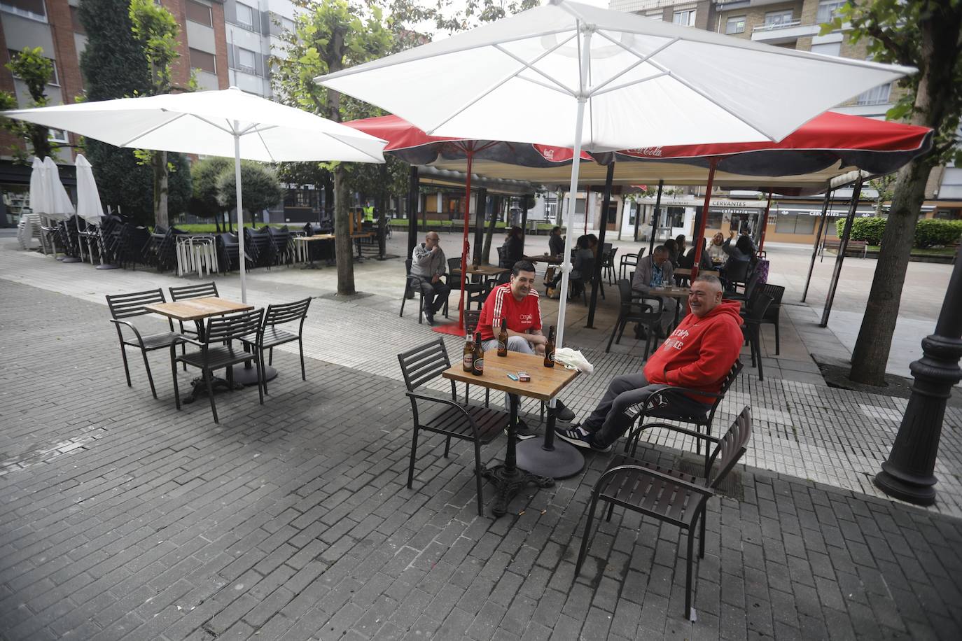 Por primera vez desde que se declaró el estado de alarma por la pandemia de coronavirus los asturianos han podido acudir a las terrazas de bares y cafeterías. Este lunes ha comenzado la fase 1 de la desescalada en el Principado y una de las medidas de alivio del confinamiento es la apertura de terrazas, aunque los establecimientos hosteleros deben acatar estrictas medidas de precaución, como la limpieza exhaustiva de las sillas y mesas o la limitación de aforo. 