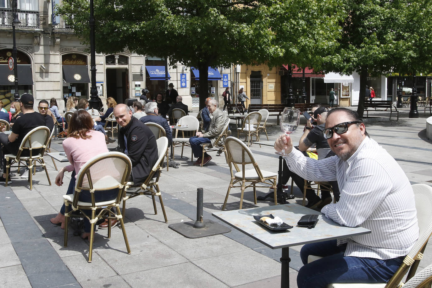 Por primera vez desde que se declaró el estado de alarma por la pandemia de coronavirus los asturianos han podido acudir a las terrazas de bares y cafeterías. Este lunes ha comenzado la fase 1 de la desescalada en el Principado y una de las medidas de alivio del confinamiento es la apertura de terrazas, aunque los establecimientos hosteleros deben acatar estrictas medidas de precaución, como la limpieza exhaustiva de las sillas y mesas o la limitación de aforo. 