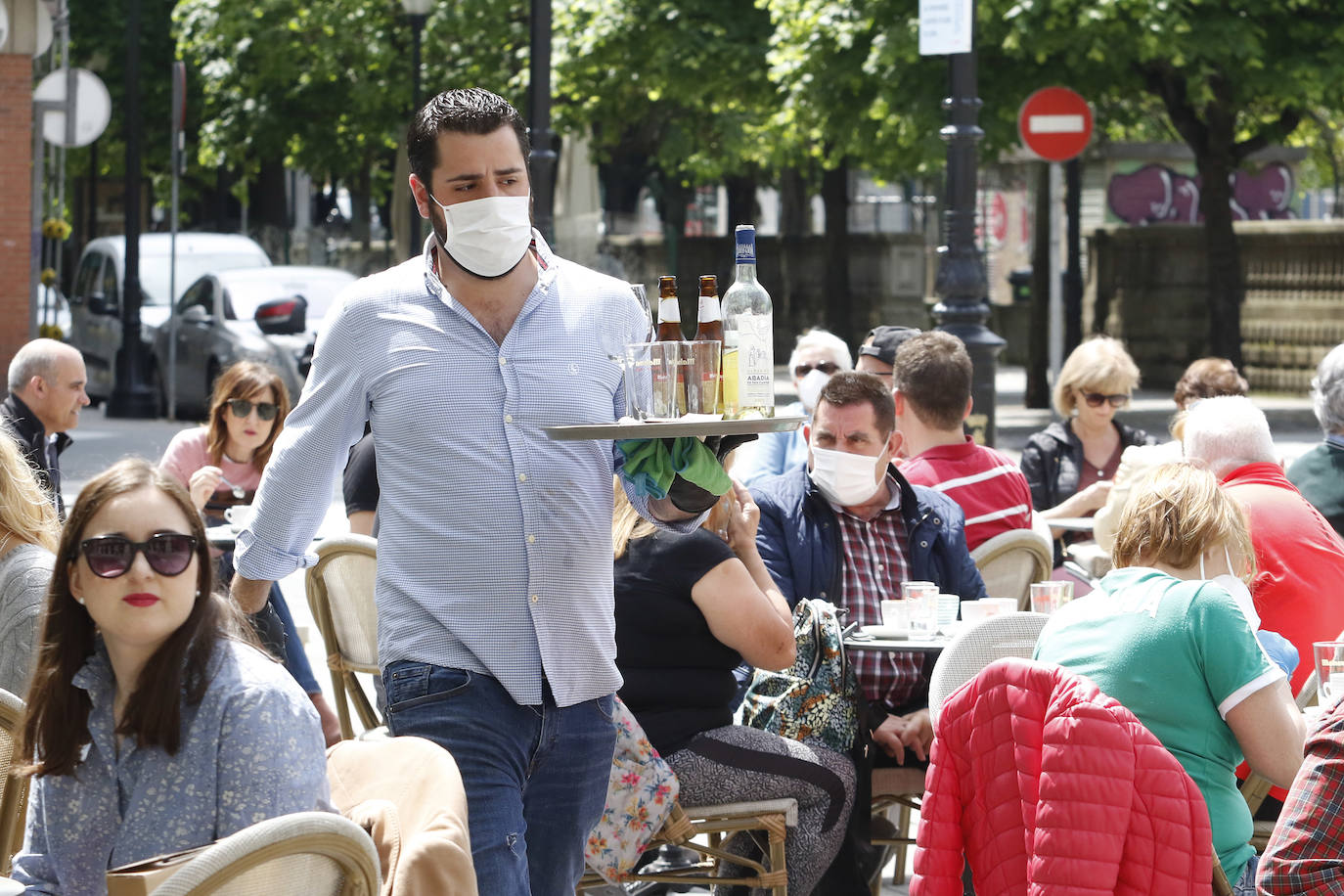 Por primera vez desde que se declaró el estado de alarma por la pandemia de coronavirus los asturianos han podido acudir a las terrazas de bares y cafeterías. Este lunes ha comenzado la fase 1 de la desescalada en el Principado y una de las medidas de alivio del confinamiento es la apertura de terrazas, aunque los establecimientos hosteleros deben acatar estrictas medidas de precaución, como la limpieza exhaustiva de las sillas y mesas o la limitación de aforo. 