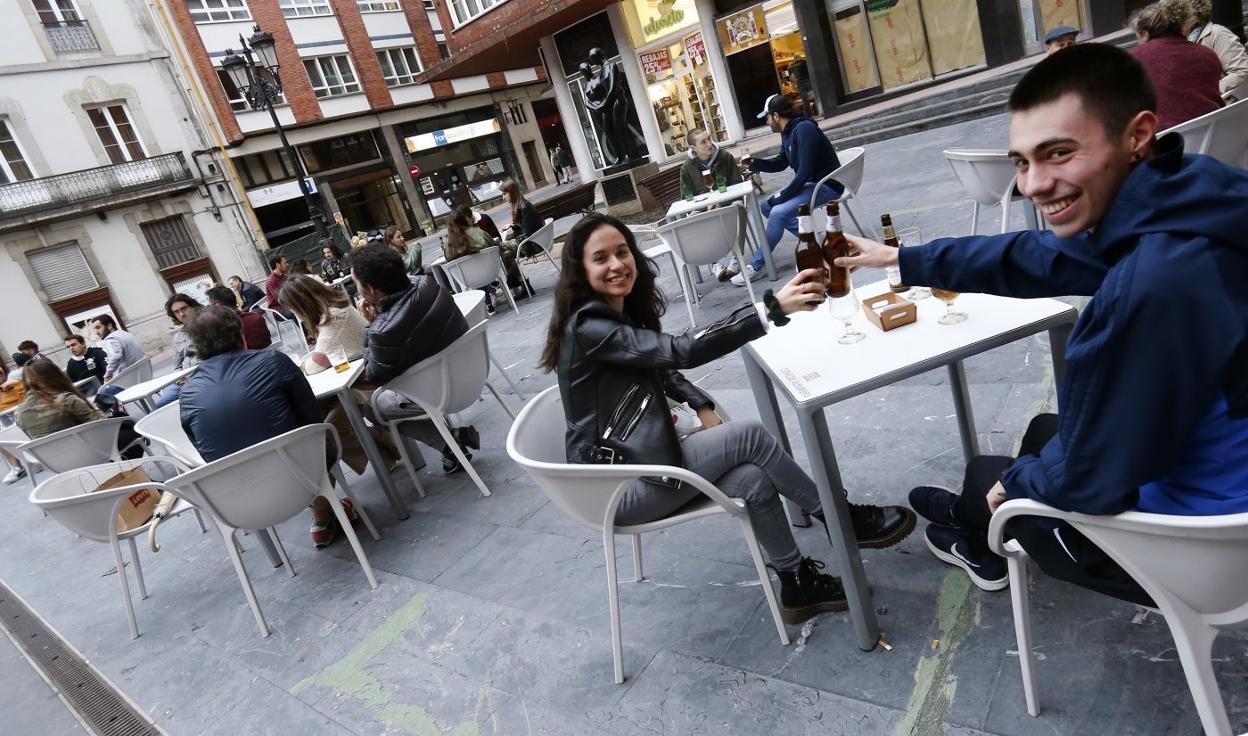 Dos jóvenes, brindando en la terraza de Casa Conrado, que ocupó con una docena de mesas la plaza de Juan XXIII desde las doce del mediodía. 