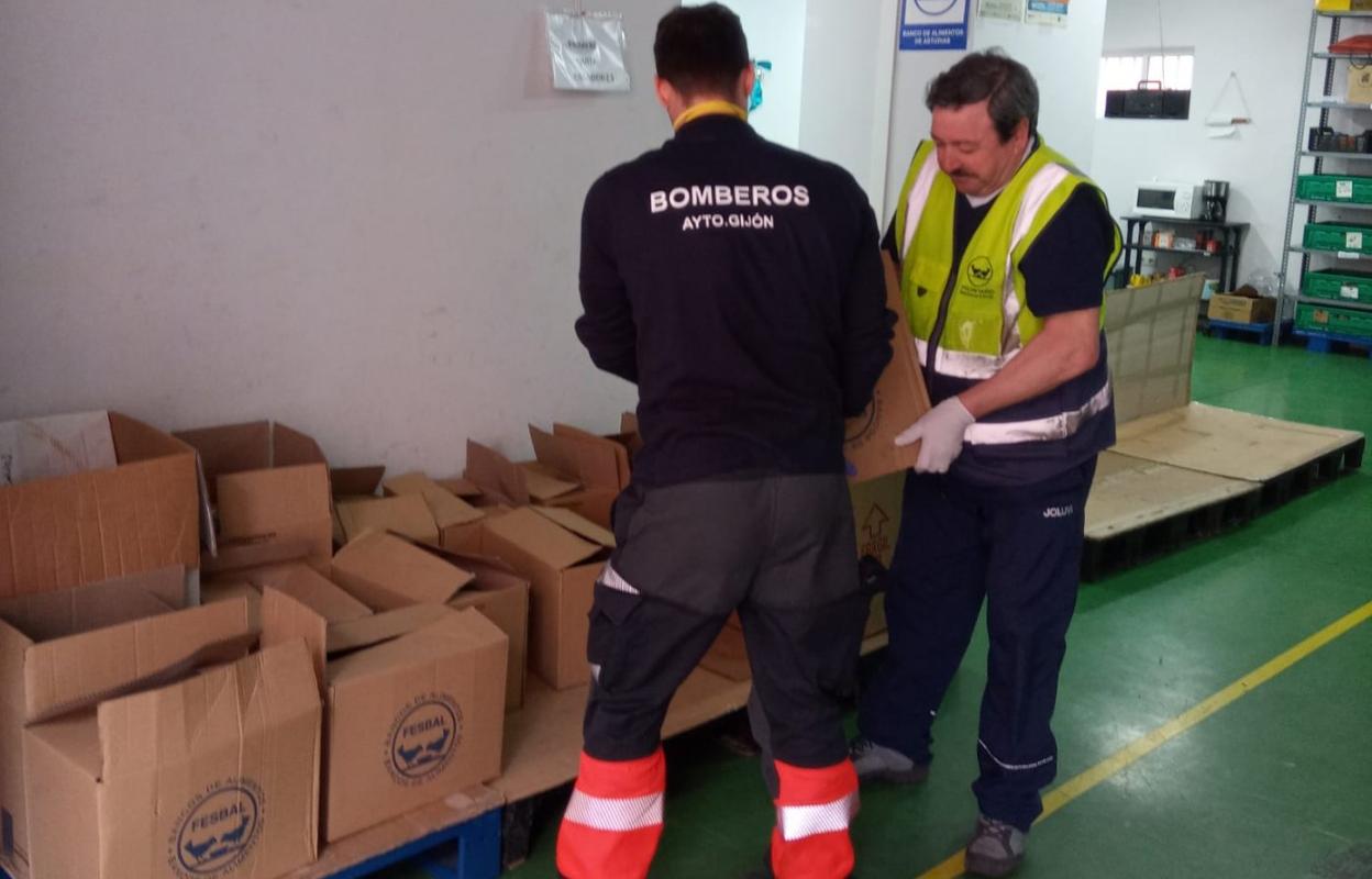 Los bomberos colocan la mercancía que repartirán a familias. 