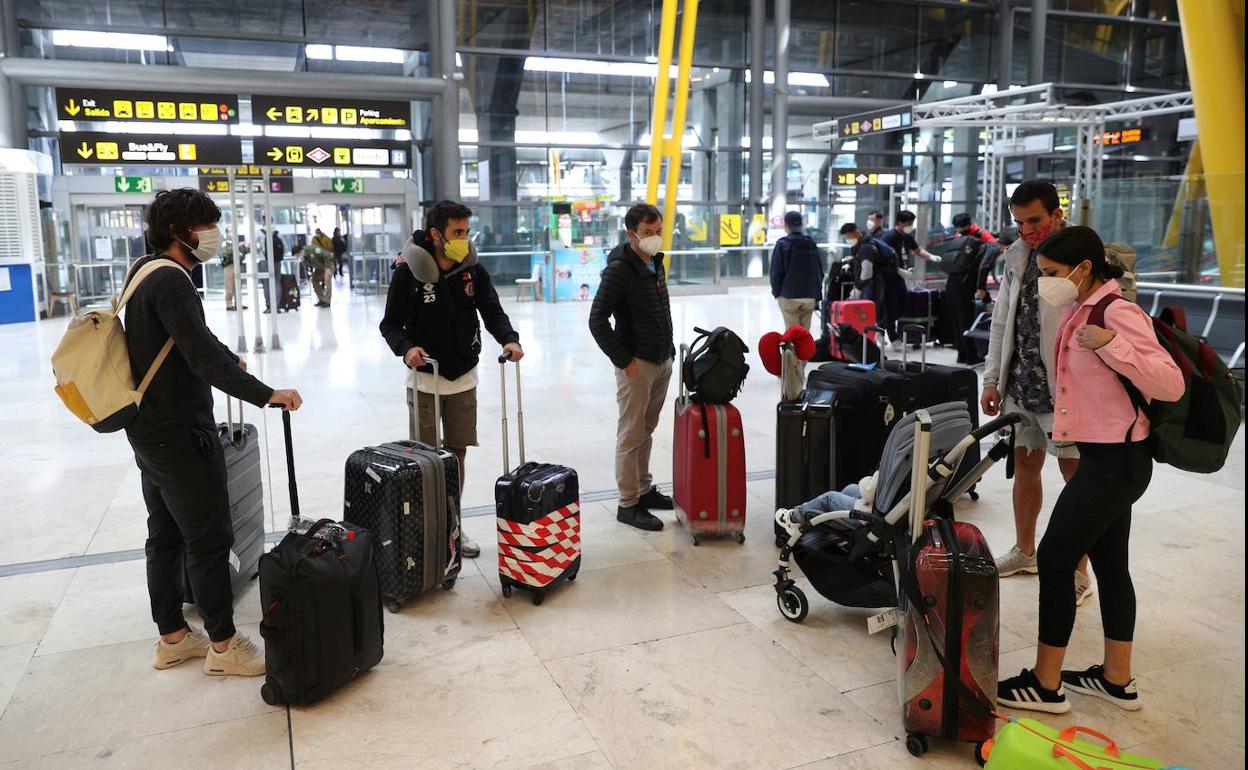 Un grupo de españoles llega al aeropuerto de Barajas desde La India.