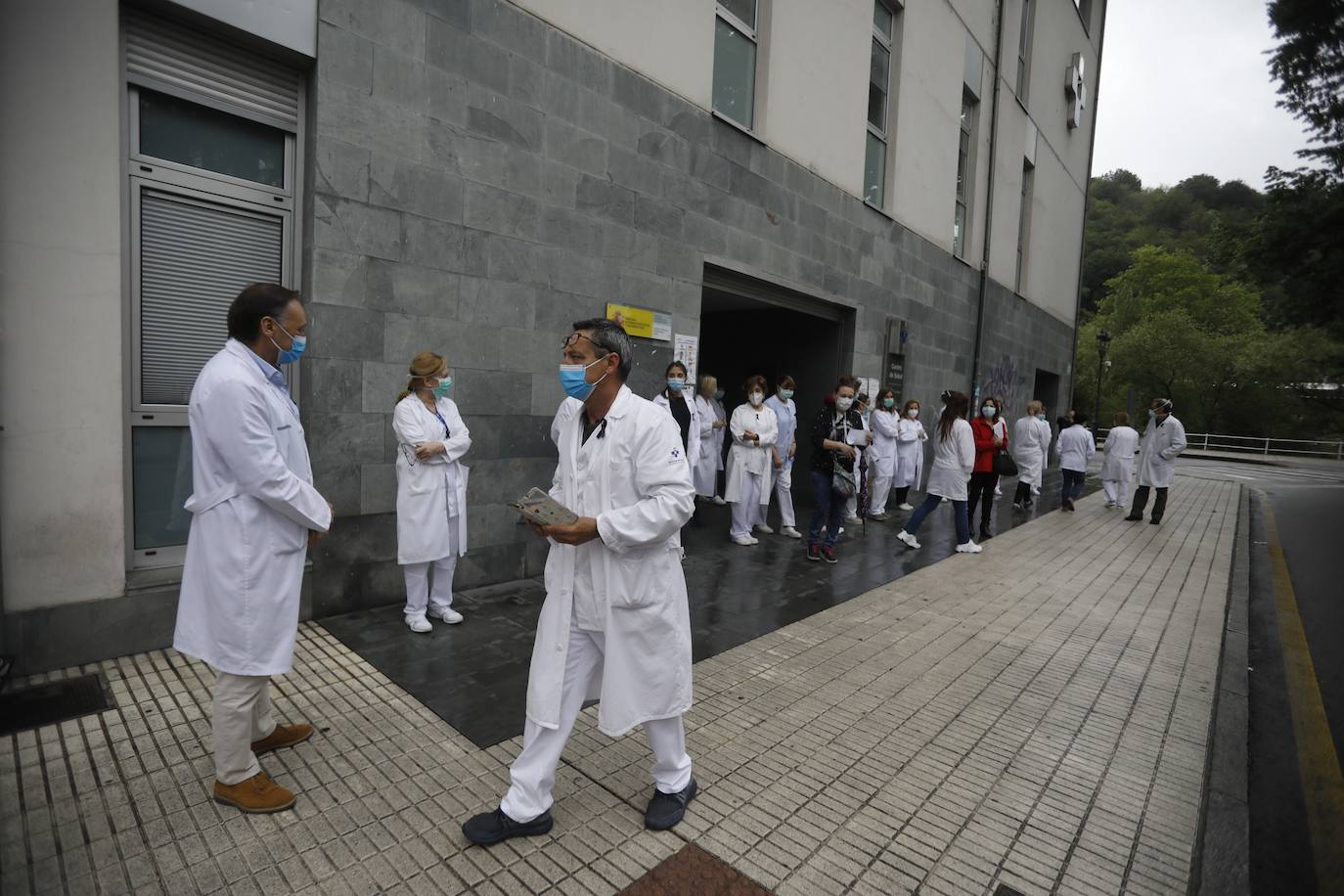 Los profesionales sanitarios del Principado de Asturias han guardado dos minutos de silencio este jueves en memoria de sus compañeros fallecidos a causa de la COVID-19. Ya son más de 49.100 los sanitarios con coronavirus en España y casi cincuenta médicos han muerto a causa de la enfermedad. En la imagen, los sanitarios del centro de salud de Sama de Langreo. 