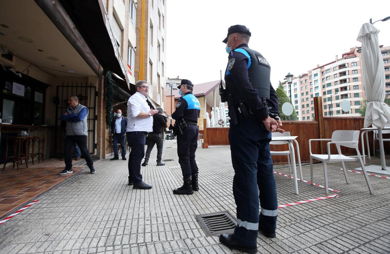 El subinspector González de la Policía Local, informando al dueño de la sidrería Pichote de la nueva norma. 