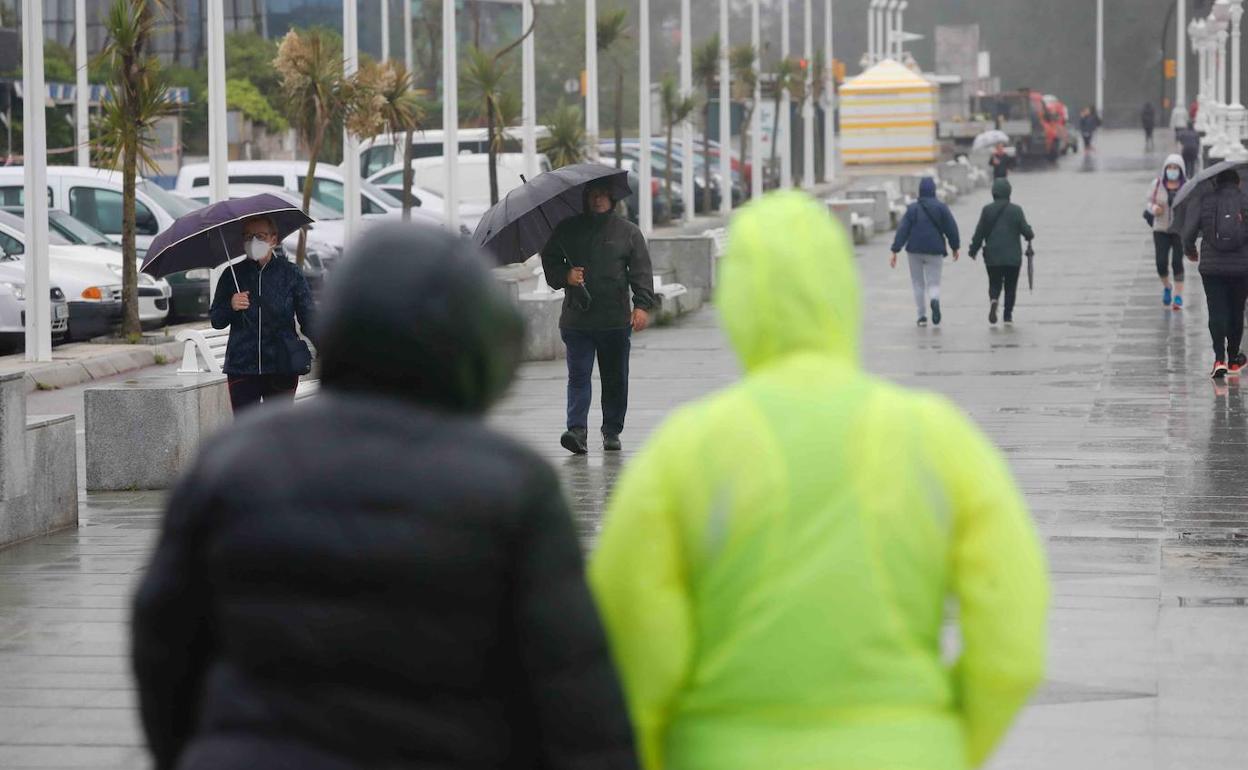 Paseantes esta mañana por Gijón en sus horarios correspondientes.