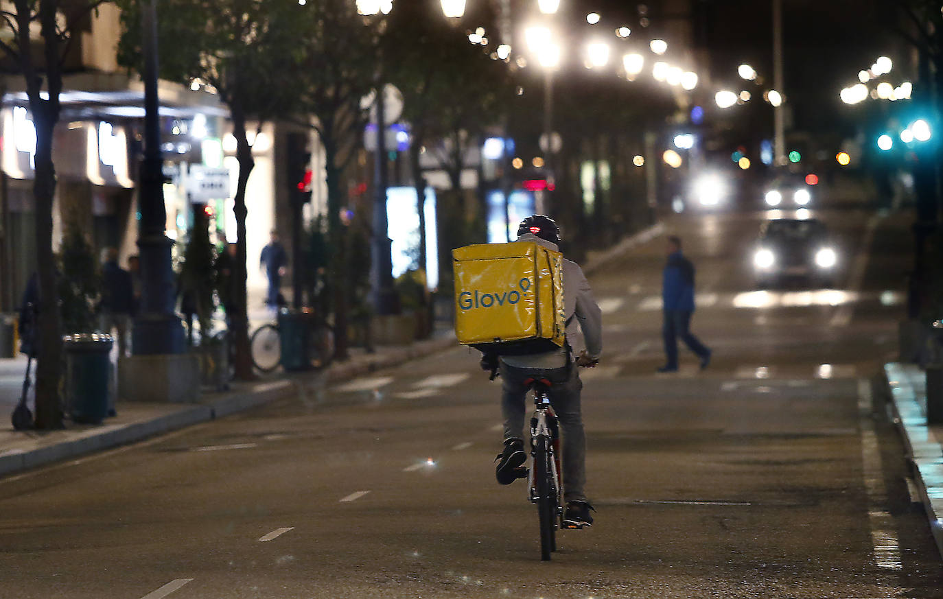 25 de marzo. Oviedo | Un repartidor de comida a domicilio circula de noche en bicicleta por Oviedo. 
