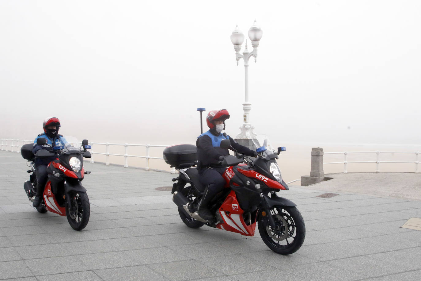 09 de abril. Gijón | Una pareja de policías locales patrullan en moto por El Muro. 