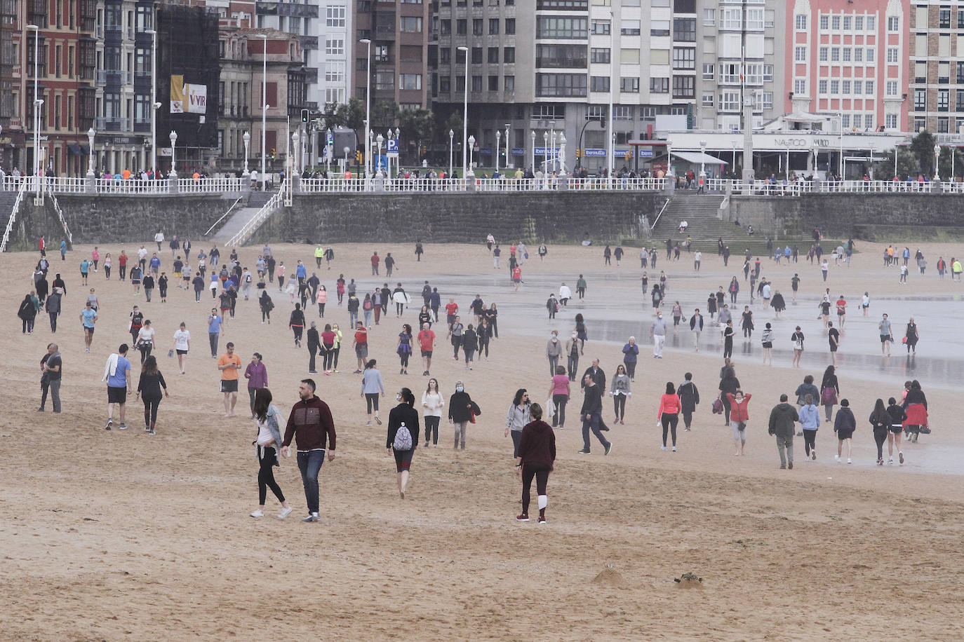 02 de mayo. Gijón | Adultos practicando deporte y paseando por la playa de San Lorenzo en la franja horaria estalecida para este segmento de la población durante la fase 0 de la desescalada del confinamiento por el coronavirus. 