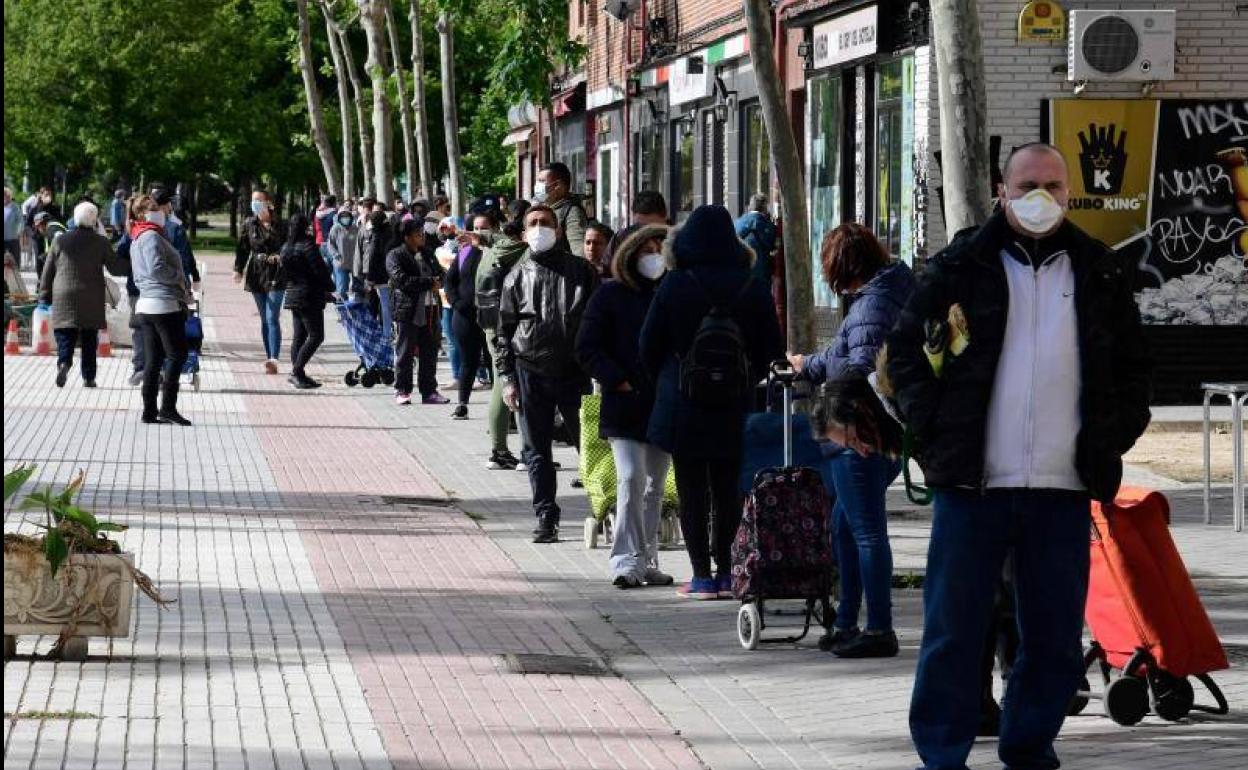 Colas para recibir ayuda alimentaria durante la crisis del coronavirus en el barrio de Aluche, en Madrid. 