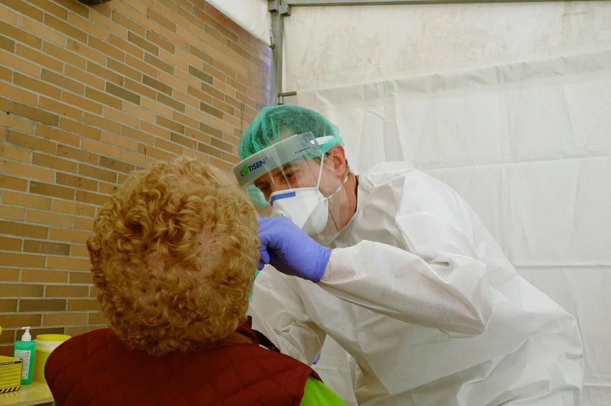 Un enfermero realiza la prueba a una paciente en la carpa. 