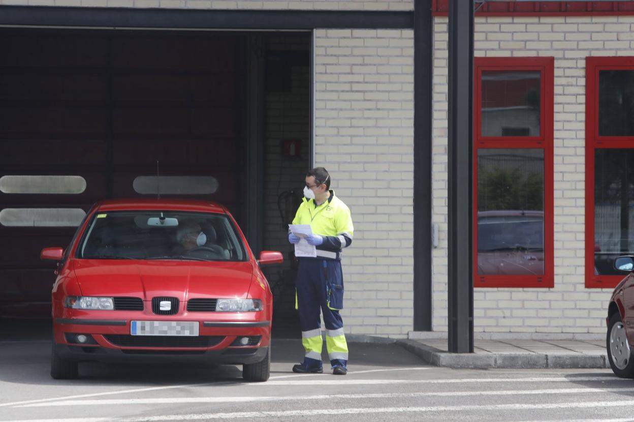 Un operario de la estación de la ITV en Gijón informa a un conductor. 