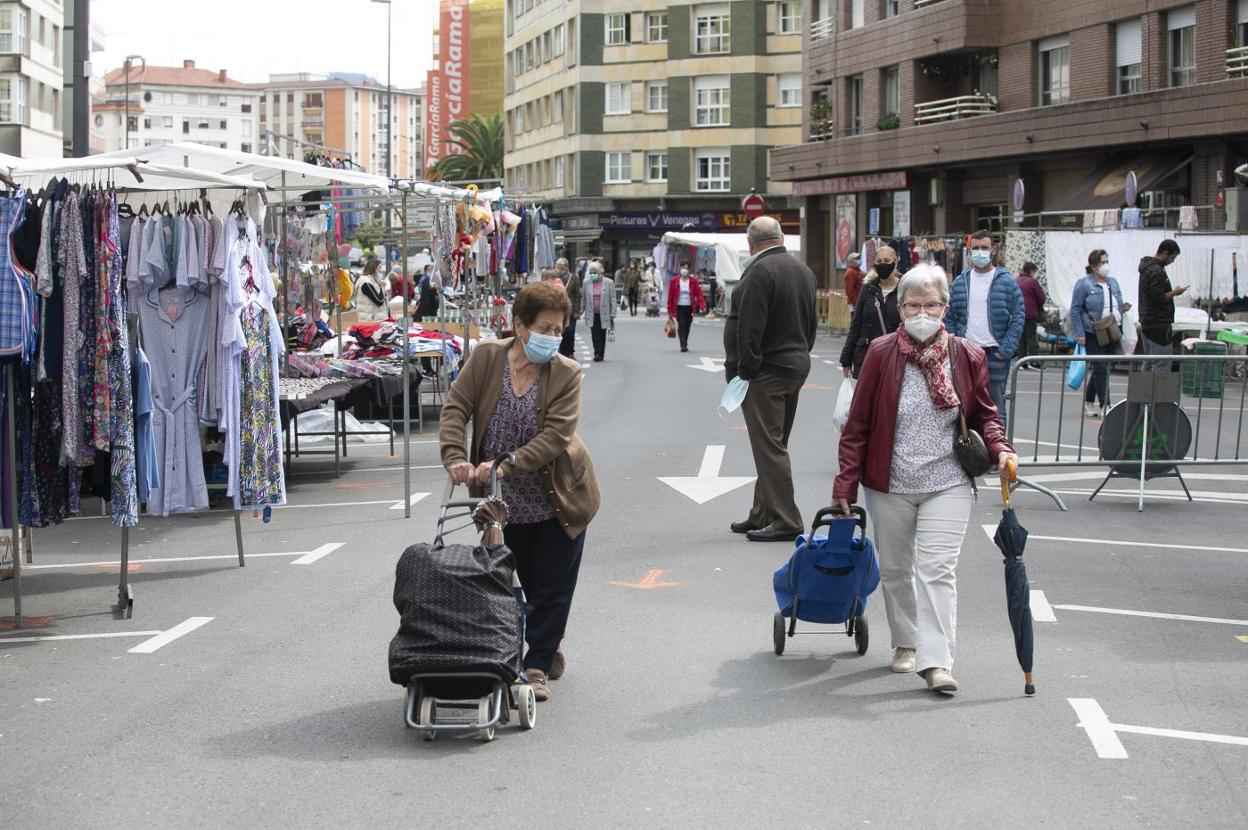 Dos mujeres recorriendo ayer el mercadillo unidireccional del barrio de La Isla, de la Pola. 