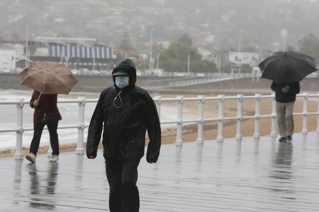 Los paseantes hacen frente al viento en San Lorenzo. 