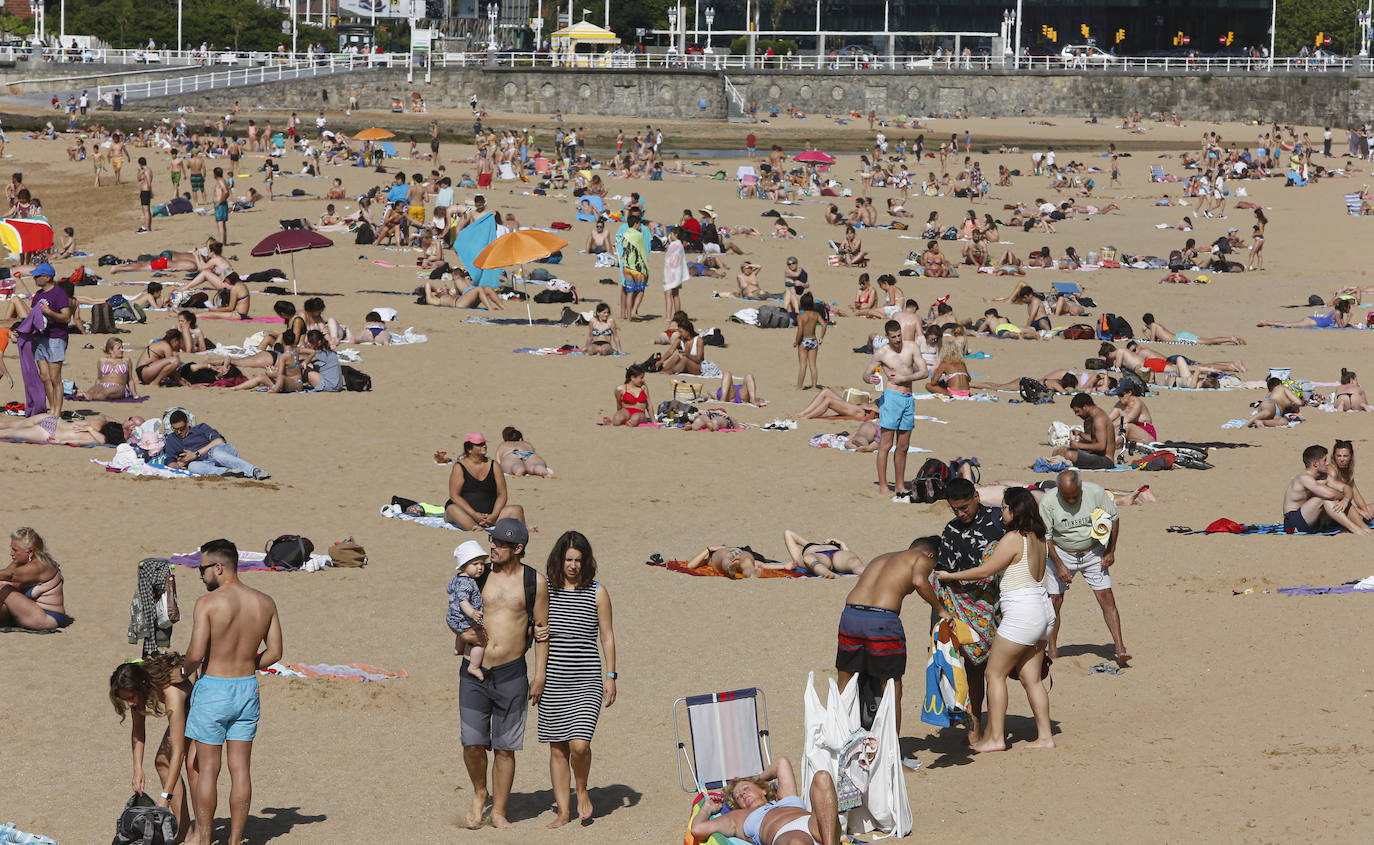 El sol y el buen tiempo han animado este jueves a disfrutar de las playas de Gijón. 