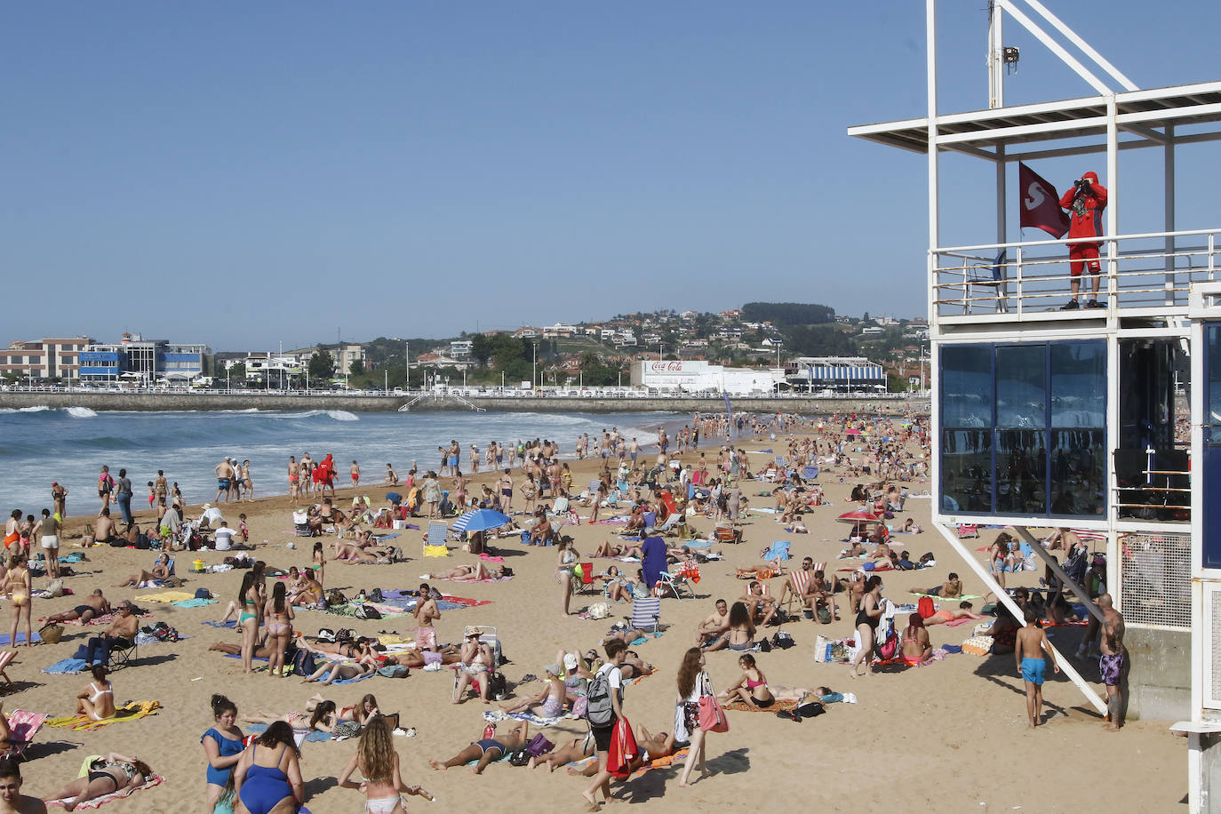 Los arenales gijoneses han vuelto este martes a llenarse de gente que ha querido pasar una nueva jornada de intenso calor tumbado en la arena o refrescándose en el agua.