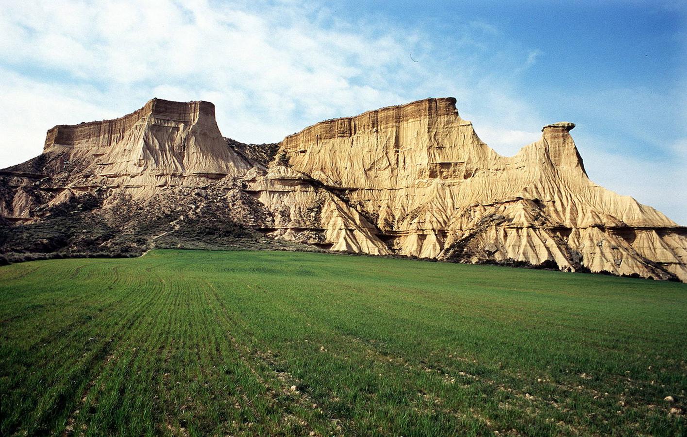 Este paisaje semidesértico de 42.500 hectáreas conformado por arcillas y areniscas es un auténtico espectáculo paisajístico al sureste de Navarra y próximo a Tudela, que durante millones de años ha sufrido los efectos de la erosión. ¿El resultado? Un paisaje árido con unas particulares formaciones rocosas, entremezcladas con zonas vertes. Actualmente estas tierras son Parque Natural desde el año 1999 y Reserva de la Biosfera desde el 2000.