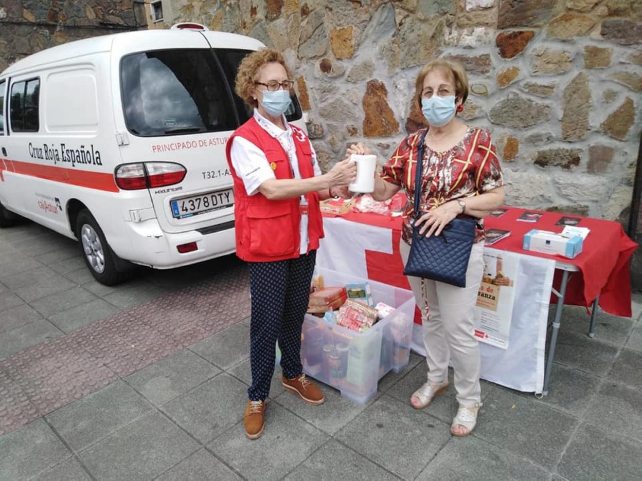 Una voluntaria recibe la aportación de una vecina en La Felguera. 