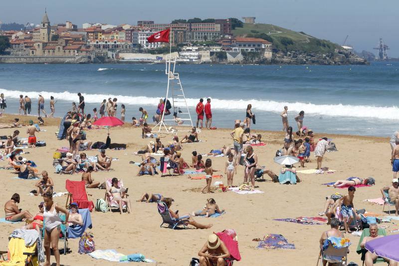 Asturianos y visitantes despiden junio con unas elevadas temperaturas que les ha llevado hasta playas y zonas de paseo con sombra.