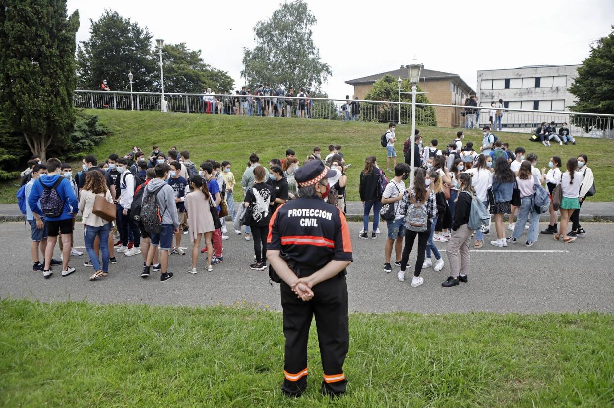 Varios alumnos aguardan la hora de entrar al Palacio de Deportes de Gijón, una de las sedes de la EBAU, bajo la vigilancia de Protección Civil. 