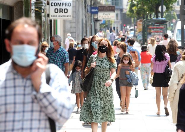 Ciudadanos con mascarilla, ayer, por las calles de Oviedo. 