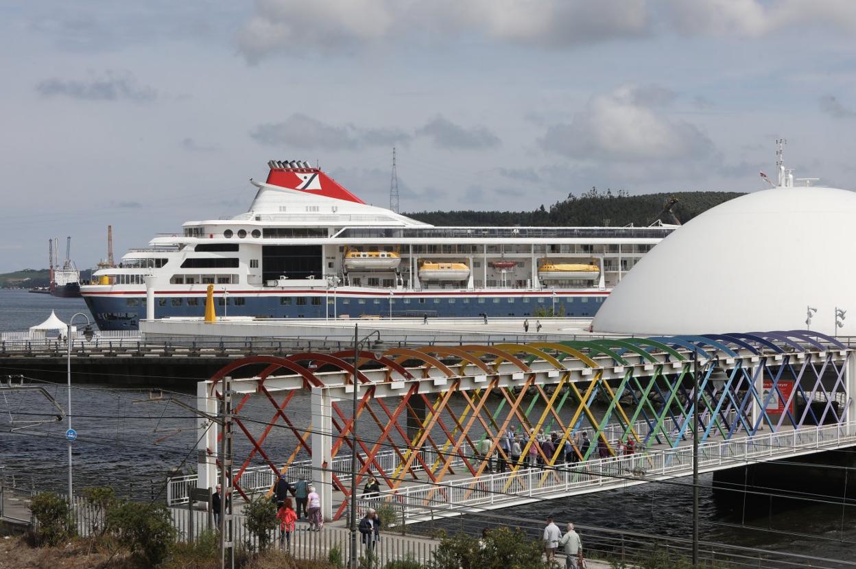 El crucero 'Braemar', atracado en la dársena de San Agustín y los viajeros regresando al barco por el puente de San Sebastián después de visitar el casco histórico. 