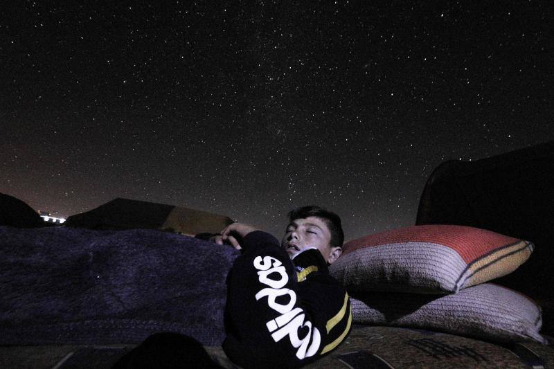 Parece que el mundo se detiene al observar el cielo estrellado de Idlib (Siria). Sin embargo, basta con bajar un poco la mirada para darse cuenta de la realidad: edificios destruidos por una guerra que comenzó hace más de nueve años y que parece no tener fin, un campamento para sirios desplazados, un parque de atracciones abandonado y combatientes a lo largo de la primera línea con las fuerzas gubernamentales. Así son las noches en la provincia de Idlib, controlada por los rebeldes sirios. 