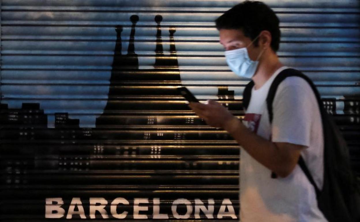 Un hombre camina por Barcelona durante la noche