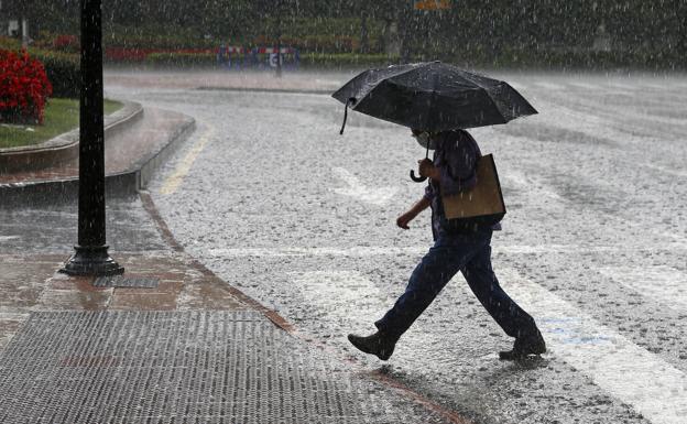 Un hombre, en Oviedo, sorprendido por la tormenta. 