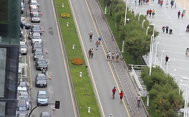 Los coches, en fila india, por la izquierda, por el único carril habilitado para el tráfico.