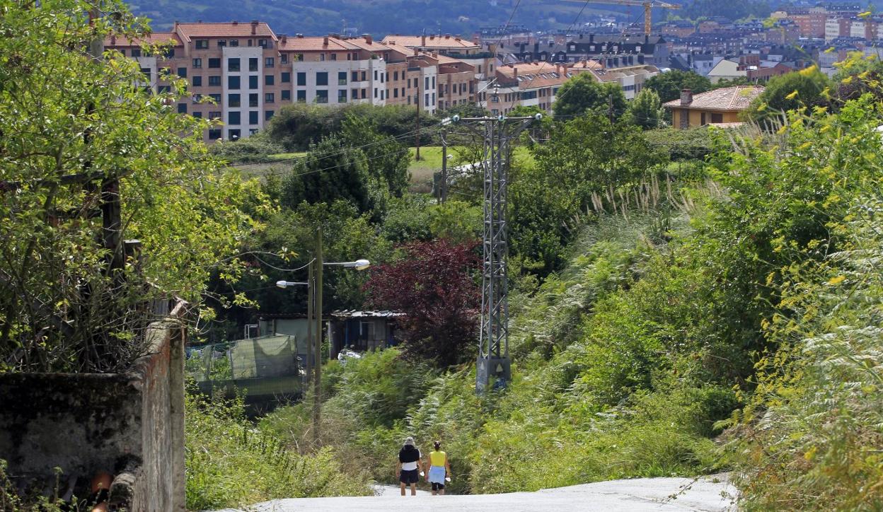 Una pareja camina por esta zona en la falda del Naranco. 