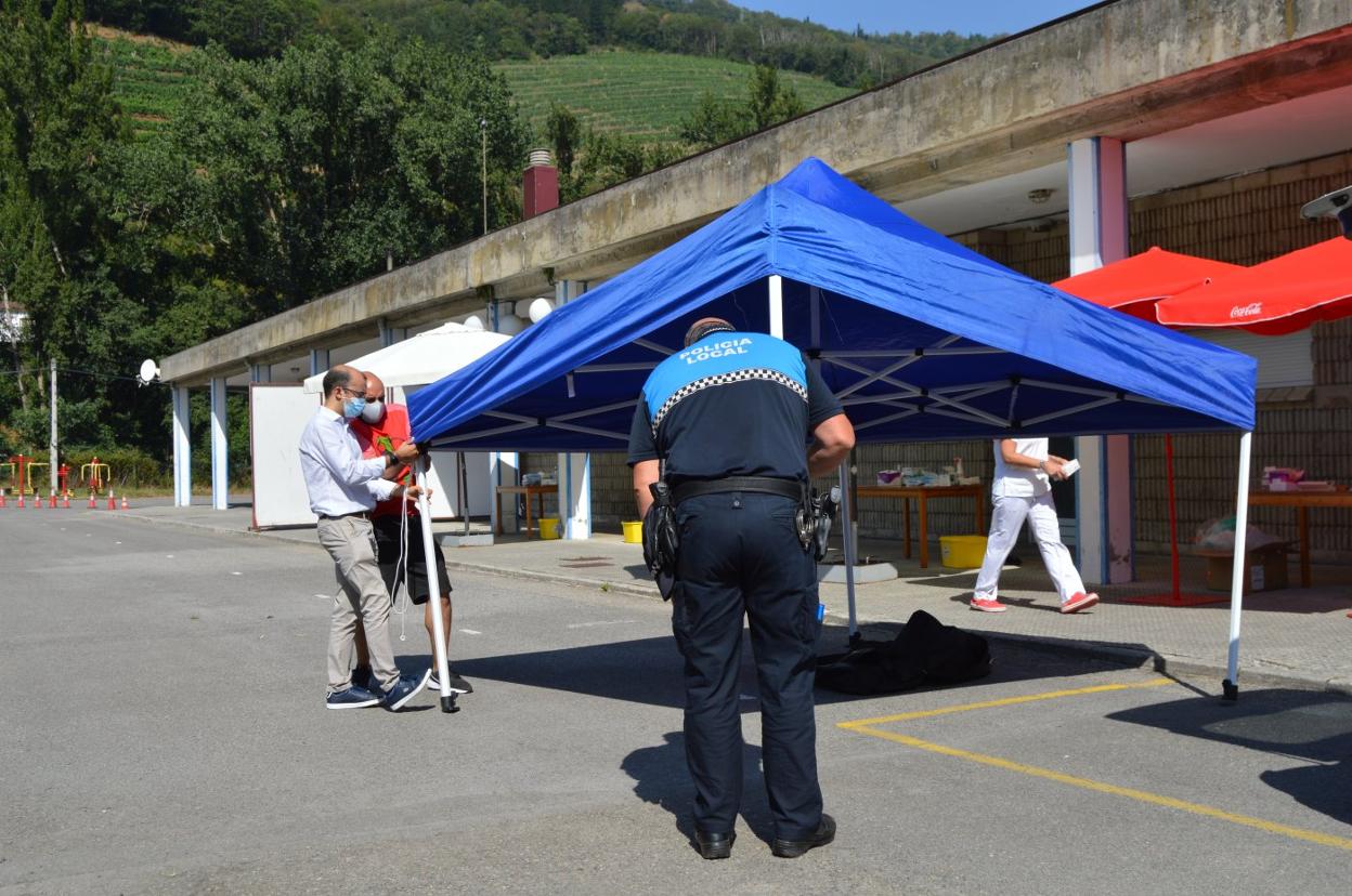 El alcalde cangués, José Víctor Rodríguez, participó en la instalación de los toldos en el autocovid. 