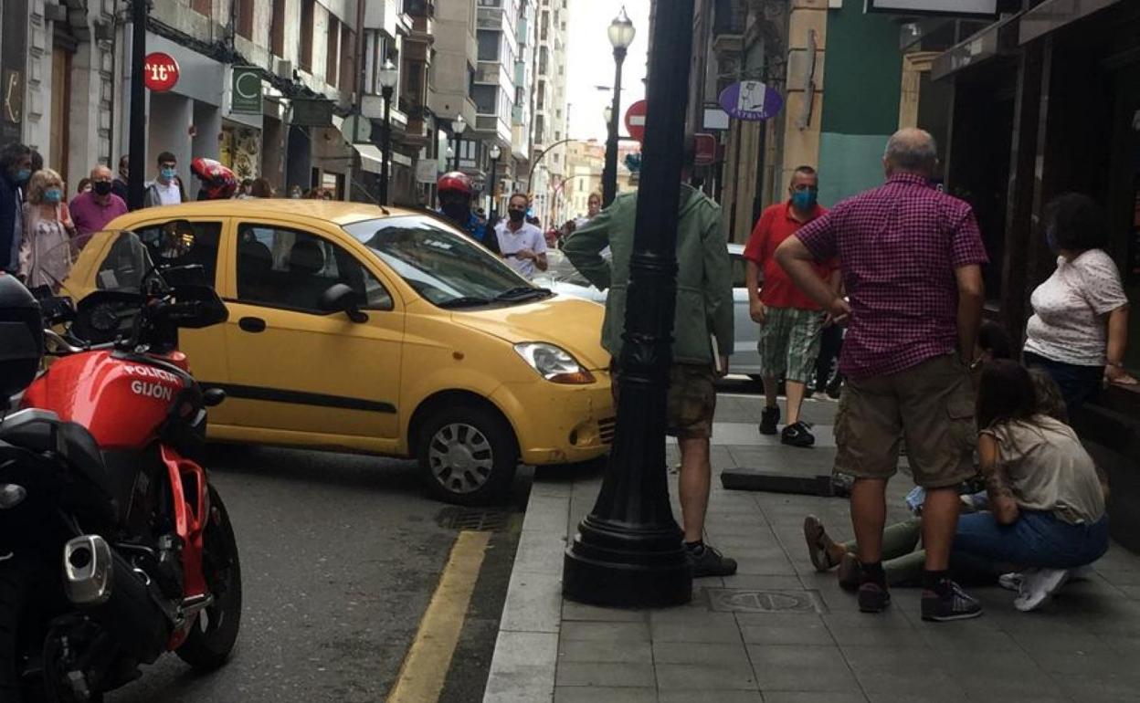 Testigos atienden a la víctima justo después de producirse el accidente en la calle Cabrales. 