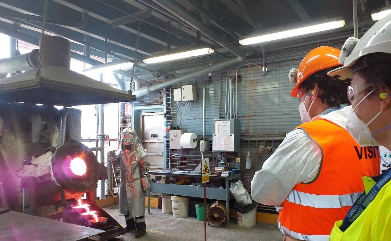 El consejero y la directora general de Orovalle, durante el proceso de fusión de lingotes.