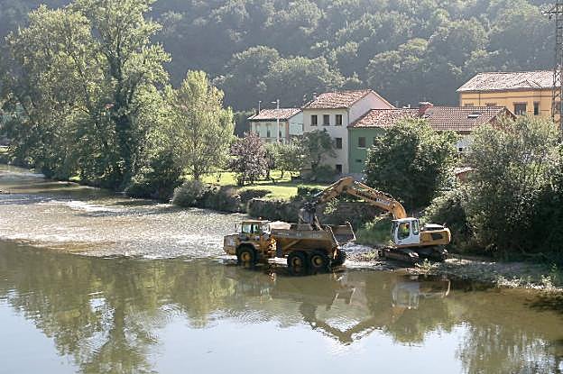 La maquinaria de Tragsa restaura el cauce del río Nalón, a la altura de Trubia, para evitar inundaciones. 