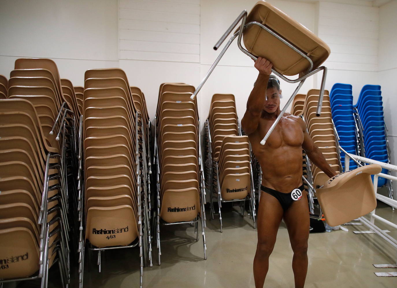 Protegidos con pantallas de plástico, decenas de concursantes compiten en el certamen de culturismo 'Mr. Tailandia' en Bangkok