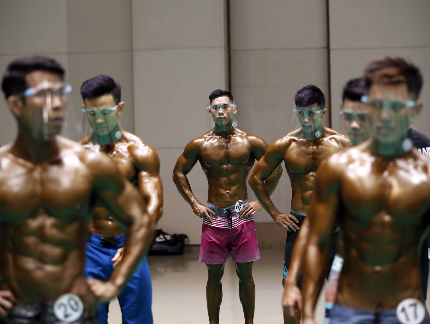 Protegidos con pantallas de plástico, decenas de concursantes compiten en el certamen de culturismo 'Mr. Tailandia' en Bangkok