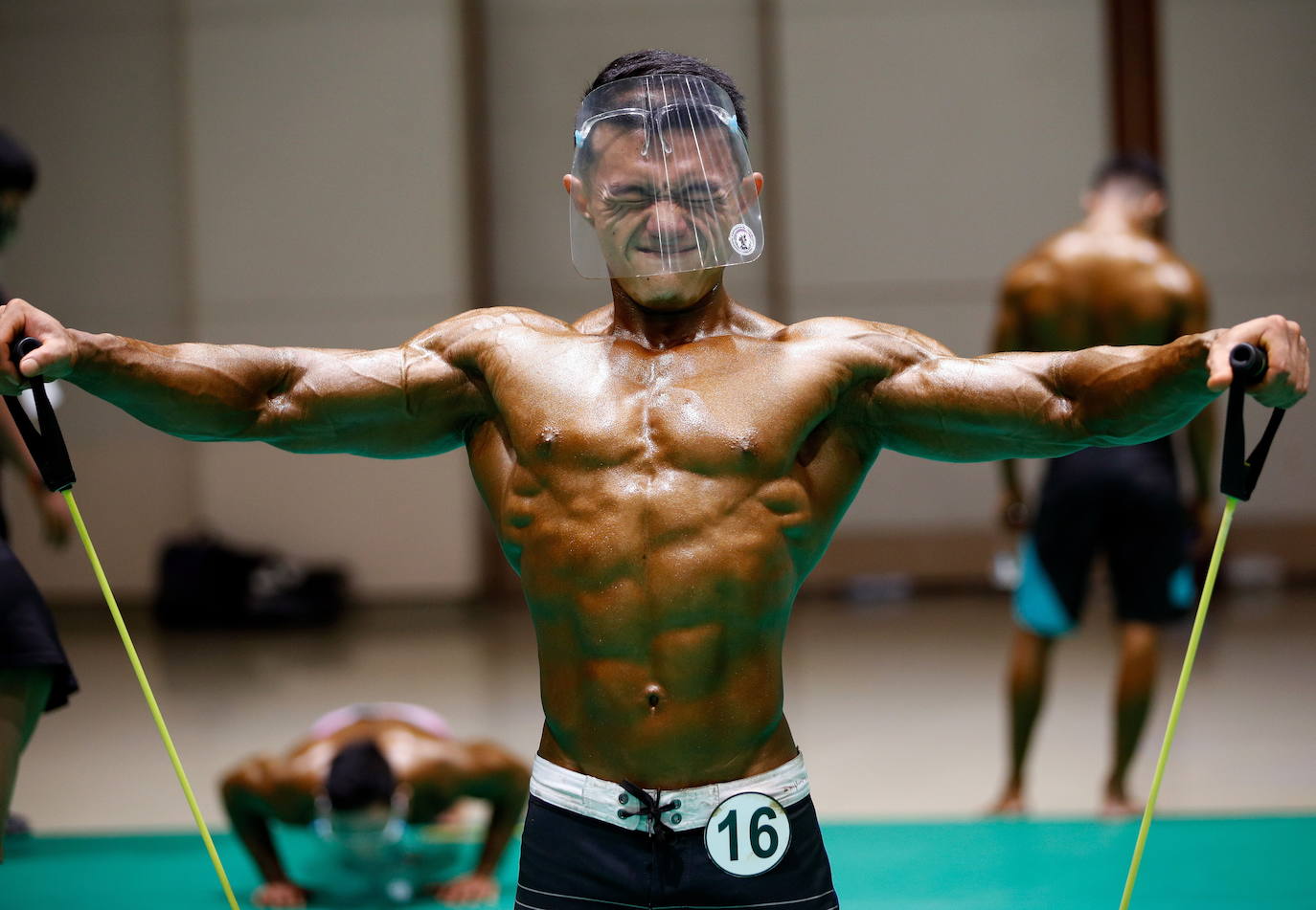 Protegidos con pantallas de plástico, decenas de concursantes compiten en el certamen de culturismo 'Mr. Tailandia' en Bangkok