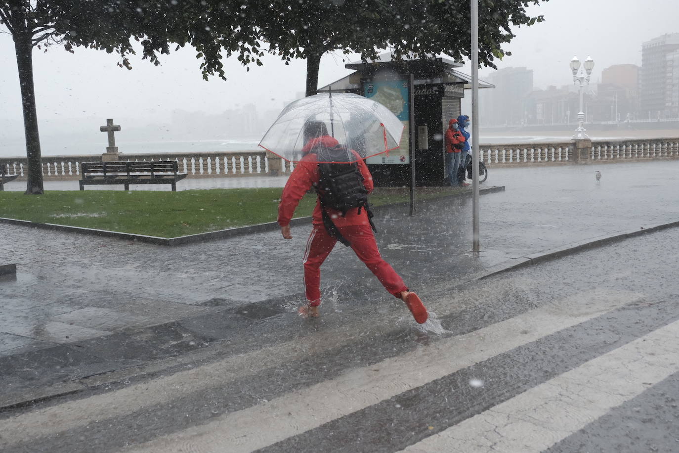 Una tromba de agua sorprendió a cuantos disfrutaban del domingo por Gijón