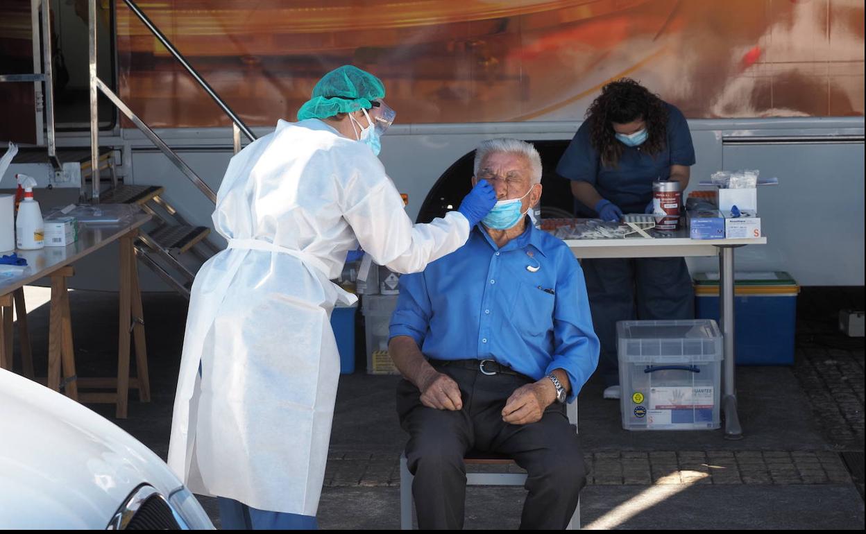 Un hombre se somete a la prueba PCR en el autoCOVID instalado en Avilés.